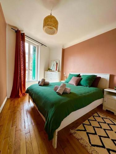 - une chambre avec un grand lit vert et une fenêtre dans l'établissement Magnifique Appartement proche Stade de France, à Saint-Denis