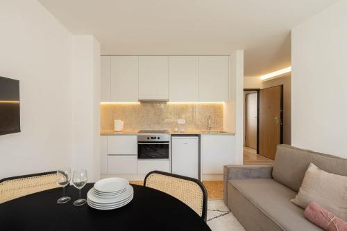 a kitchen and living room with a table and a couch at Azul Downtown Apartments in Coimbra