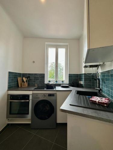 Il comprend une cuisine équipée d'une cuisinière et d'un lave-vaisselle. dans l'établissement Magnifique Appartement proche Stade de France, à Saint-Denis