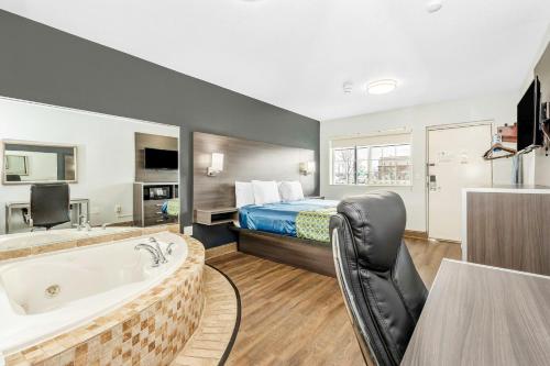 a hotel room with a tub and a bed at Grove City Travel Inn South Columbus in Grove City