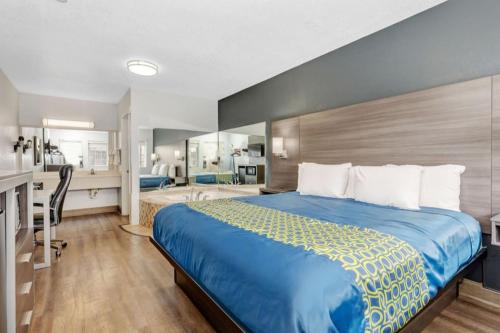 a hotel room with a bed and a bathroom at Grove City Travel Inn South Columbus in Grove City