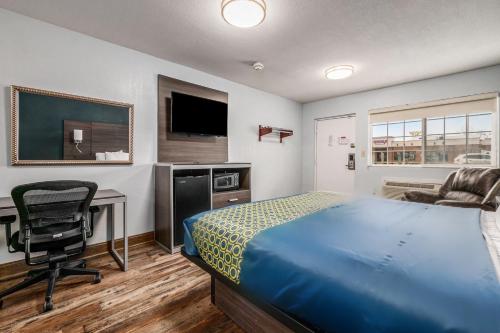 a bedroom with a bed and a desk and a chair at Grove City Travel Inn South Columbus in Grove City