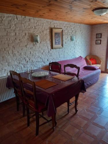 une salle à manger avec une table et un canapé dans l'établissement petit gîte de montagne avec jardin et terrasse, à Cazaux-Layrisse