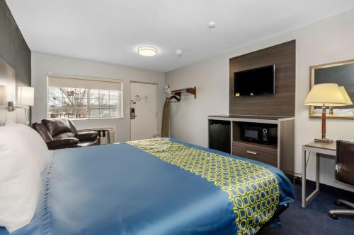 a hotel room with a bed and a television at Grove City Travel Inn South Columbus in Grove City