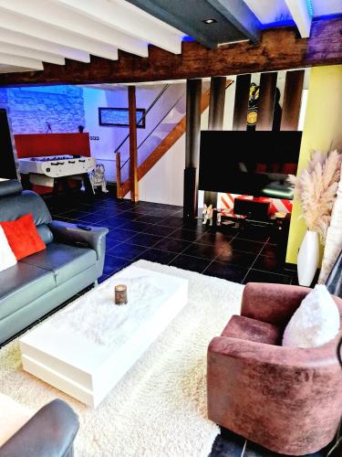 a living room with a couch and a tv at Maison cosy piscine jacuzzi sauna in Épervans