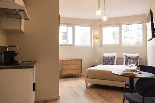 une chambre avec un lit, une table et des fenêtres dans l'établissement Studio paisible et confortable Paris 19, à Le Pré-Saint-Gervais