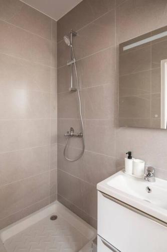 une salle de bain blanche avec une douche et un lavabo dans l'établissement Studio paisible et confortable Paris 19, à Le Pré-Saint-Gervais