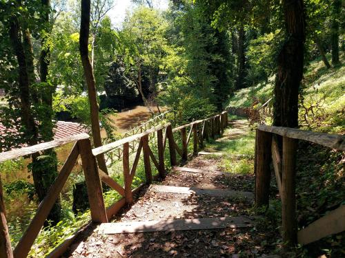 a wooden fence on a path in the woods at 2 Bed House with Mountain View Garden and Bbq in Confolens
