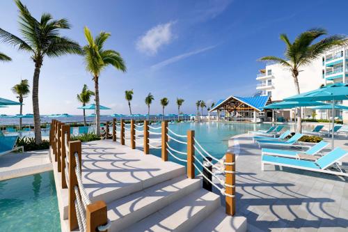 a pool at the resort with chairs and palm trees at Margaritaville Island Reserve Riviera Maya - An Adults Only Karisma All-Inclusive Experience in Puerto Morelos