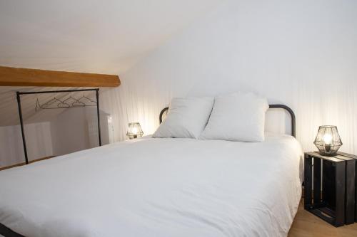 - une chambre avec un lit blanc et 2 lampes dans l'établissement Grand Duplex avec billard, à Villeneuve-Tolosane