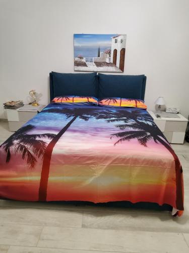 a bed with a colorful bedspread with a palm tree at Appartamenti Bellavista 107 in Chioggia