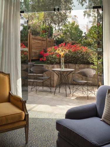 a living room with chairs and a table and flowers at Miraflores Park, A Belmond Hotel, Lima in Lima