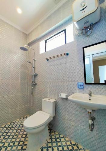 a bathroom with a toilet and a sink at Carstenzs Home Kuta in Kuta