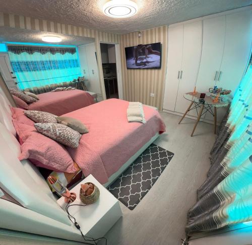 una camera da letto con letto e lenzuola e cuscini rosa di Gold House Oro a Hacienda Mera