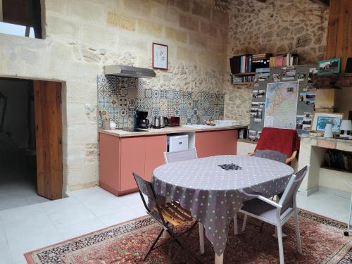 une cuisine avec une table et des chaises dans une pièce dans l'établissement Duplex Girondin avec Piscine, à Izon
