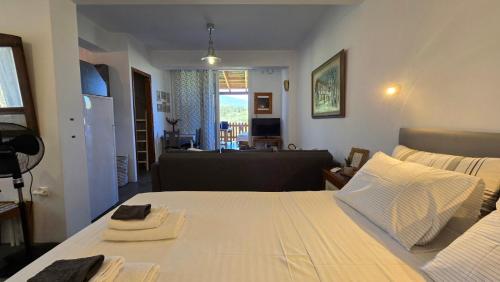 a bedroom with a large white bed and a living room at Konti villa in Kondáraina