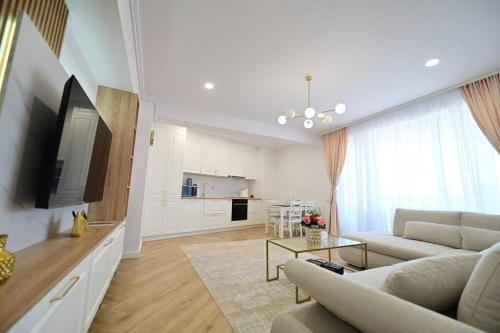 a living room with a couch and a tv and a table at FLH - SIBIU - The Evolution LUXURY Apt - 2 Bedrooms, 1 Livingroom, 2BA with 3 ACs Units and Panoramic view - Sleeps 6 - Shopping City Mall in Şelimbăr