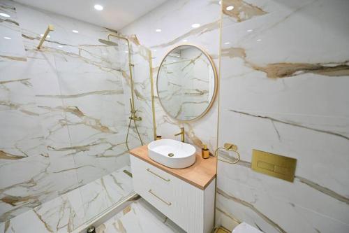 a bathroom with a sink and a mirror at FLH - SIBIU - The Evolution LUXURY Apt - 2 Bedrooms, 1 Livingroom, 2BA with 3 ACs Units and Panoramic view - Sleeps 6 - Shopping City Mall in Şelimbăr