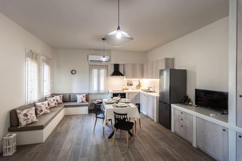 a kitchen and a living room with a table and chairs at Aggelika's House in Batsi