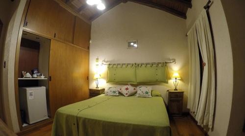 a bedroom with a green bed with two lamps at Pilgrim's Rest - Descanso del Peregrino in Chacras de Coria