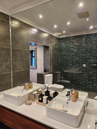 a bathroom with two sinks and a large mirror at The Residence in Johannesburg