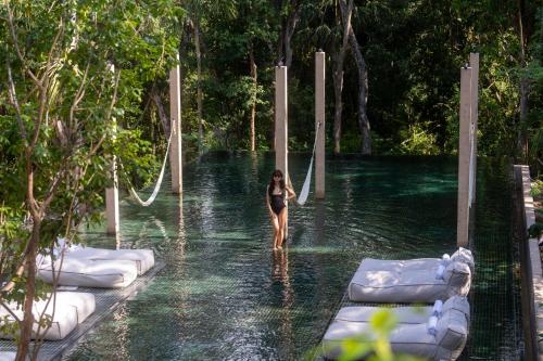 a woman walking through a pool of water at Boca de Agua Bacalar in Bacalar