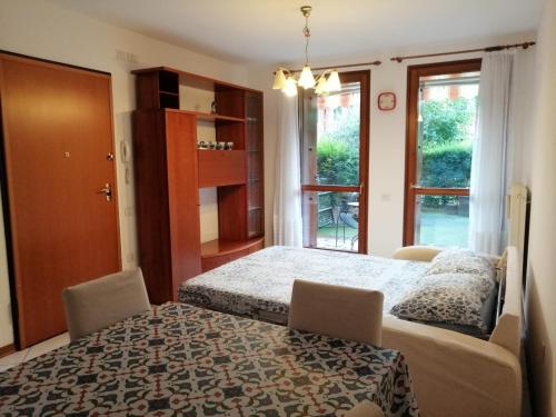 a bedroom with a bed and two chairs and a window at HomeSweetHome in Cormòns