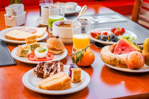 una mesa cubierta con platos de comida y bebida en Hotel Fioreze Origem en Gramado