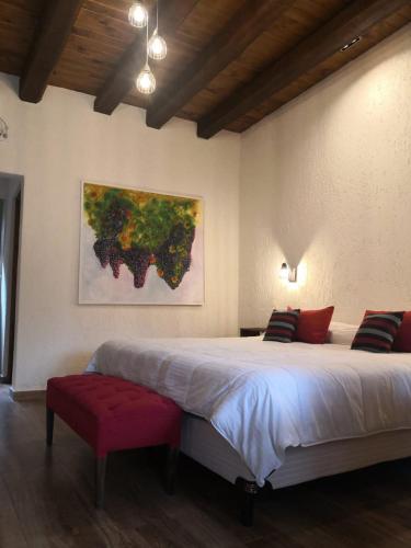 a bedroom with a large bed and a painting on the wall at Pilgrim's Rest - Descanso del Peregrino in Chacras de Coria
