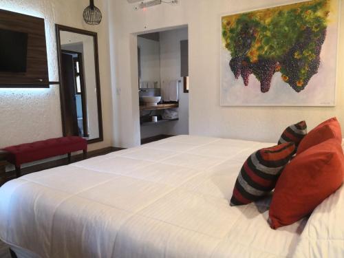 a bedroom with a large white bed with two pillows at Pilgrim's Rest - Descanso del Peregrino in Chacras de Coria