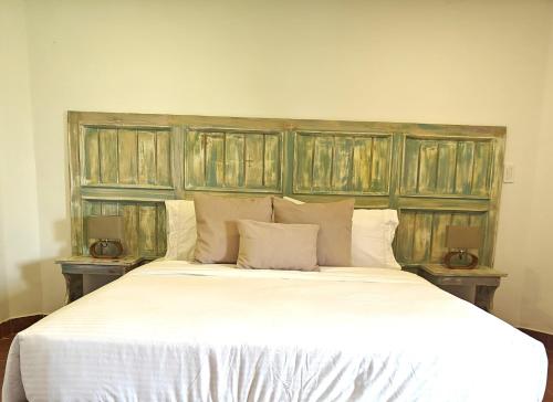 a bedroom with a large white bed with wooden headboard at Zenith Bed & Breakfast in Pereira