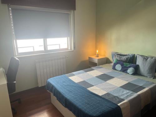 a bedroom with a bed with a blue and white blanket at Relaxing Guesthouse - Sónias Houses in Lisbon