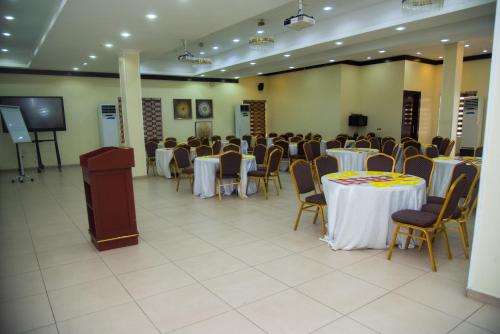 a banquet hall with tables and chairs and a podium at Golden Tulip Garden City Hotel - Rivotel in Port Harcourt