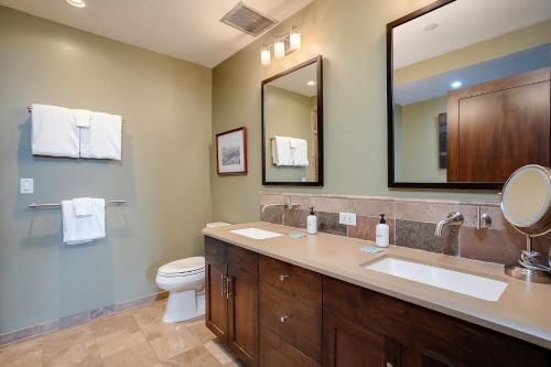 Un baño con lavabo, inodoro y espejo. en Expansive Luxury Condo - Downtown - Summer AC, en Steamboat Springs