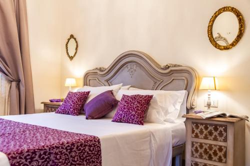 - une chambre avec un grand lit et des oreillers violets dans l'établissement Tenuta Fiumara, à Marina di Grosseto