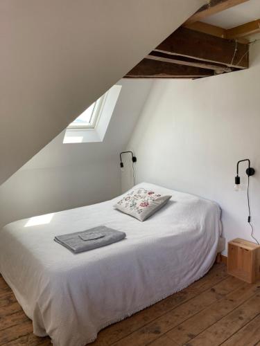 a bedroom with a white bed in a attic at chambre chez l'habitant in Mauléon-Licharre