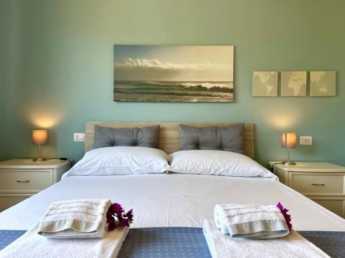 a bedroom with a large white bed with two pillows at Maison Panorama - Portofino View in Lavagna