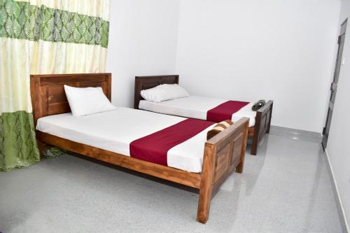 two twin beds in a room withthritisthritisthritisthritisthritisthritisthritisthritisthritis at Wellassa Sisila in Wellawaya