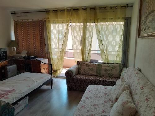 un salon avec un canapé et une fenêtre dans l'établissement Studio Boulouris Saint Raphael, à Saint-Raphaël