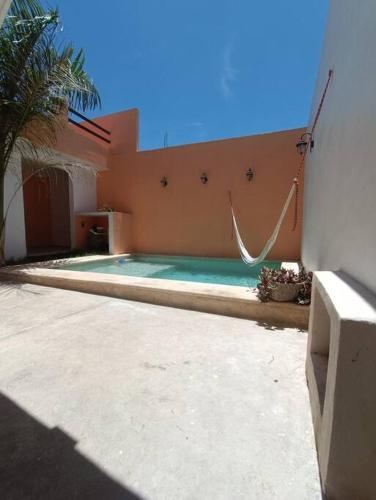 a swimming pool with a hammock in a house at Departemento El tuch in Campeche