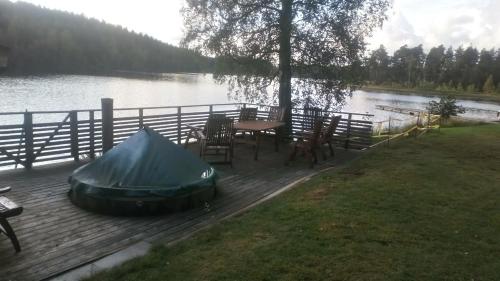 a tent sitting on a wooden deck next to a lake at Stuga im Wald mit Seeblick, nahe Vimmerby in Vena
