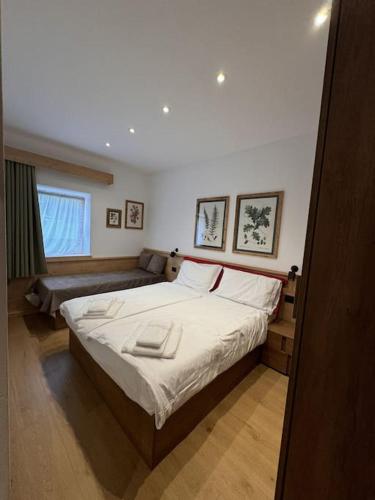 a bedroom with a large bed and a couch at Appartamento Continental - 8 posti letto in San Vito di Cadore