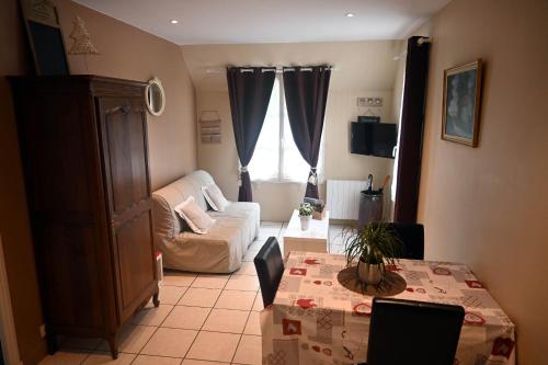 een woonkamer met een bank en een tafel bij Aux Cottages du port Honfleur in Honfleur