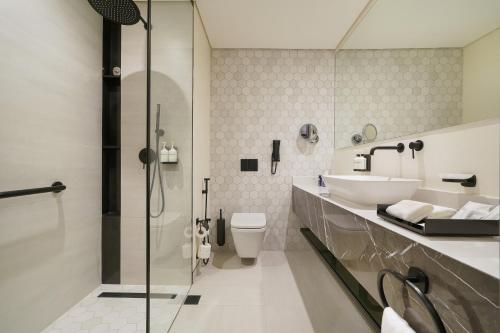 Un baño con lavabo, inodoro y ducha. en Nova M Hotel, Edge by Rotana, en Riad