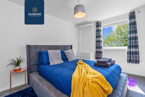 a bedroom with a bed with blue sheets and a window at Springhill Townhouse - INVOICE and REDUCED PRICE only via SUNRISE SHORT LETS DUNDEE, 3 Bedrooms, 2 Kings, 1 Single, Great Views, Newly Refurbished, Free Parking, Free Wifi, River View, Dock, Eden Views in Dundee