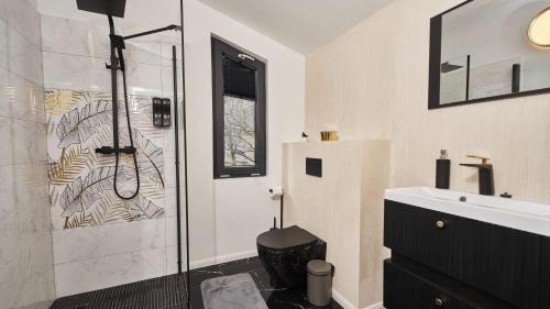 a bathroom with a shower and a sink at Blissful Resort - Valea Doftanei in Teşila