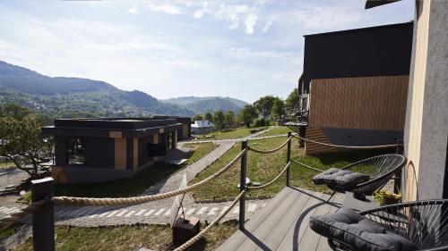 a balcony with a view of a building and mountains at Blissful Resort - Valea Doftanei in Teşila