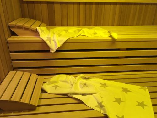 a sauna with a bed and a bench with yellow sheets at Goldener Hahn Residence Ferienwohnungen mit Infrarot Sauna, Panorama Aussicht & Pool, Frühstücksservice im Aparthotel in Baiersbronn