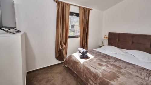 a bedroom with a large bed and a window at Blissful Resort - Valea Doftanei in Teşila