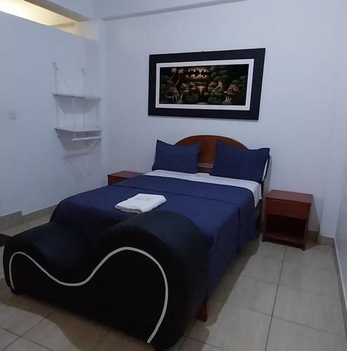 a bedroom with a blue bed with blue pillows at Hospedaje Moralillos in Yurimaguas